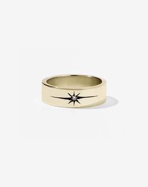 A 9ct yellow gold flat band with a central diamond set in an elongated star setting, creating a dramatic effect.