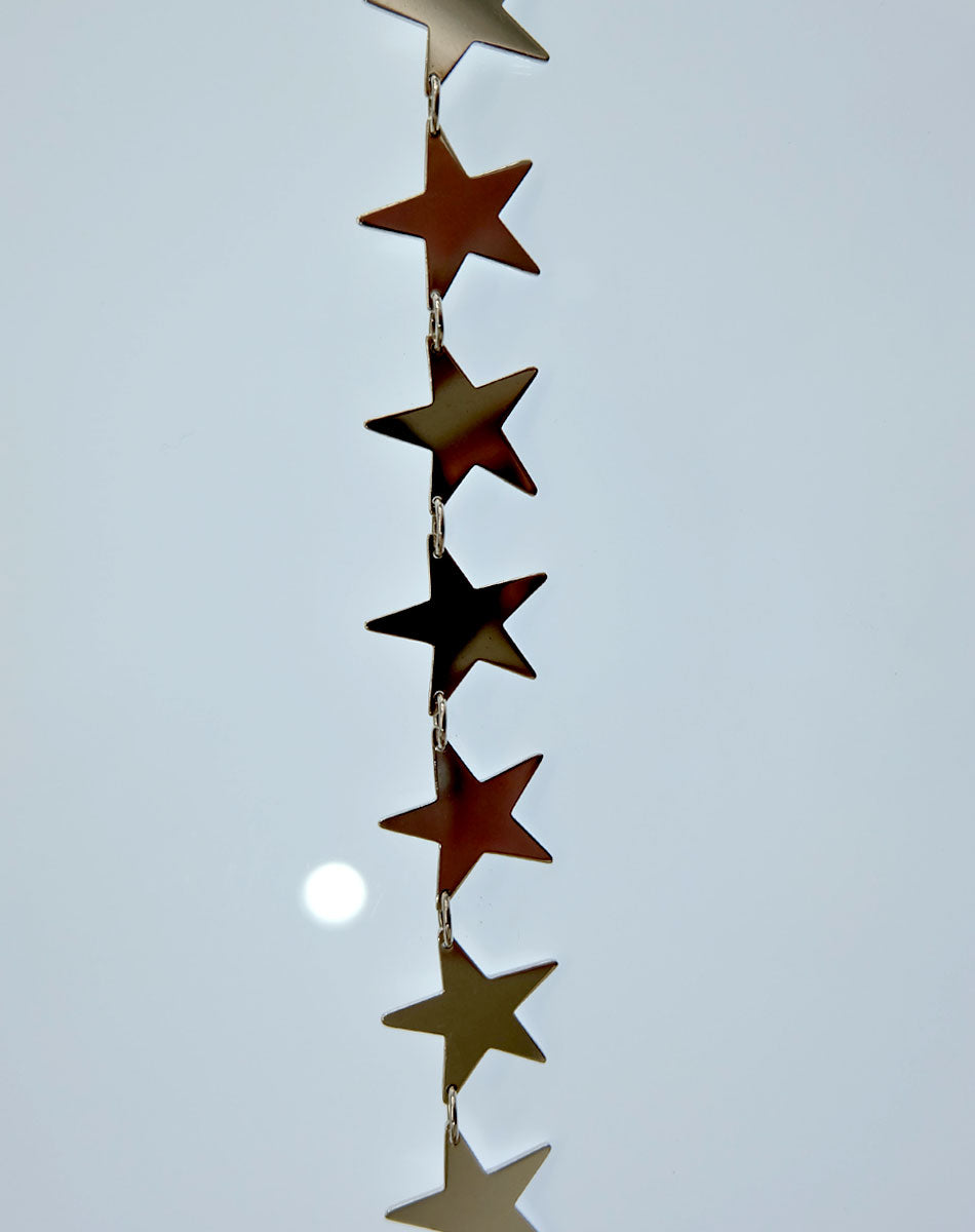 A sterling silver necklace with a series of star-shaped charms linked together.