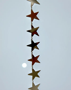 A sterling silver necklace with a series of star-shaped charms linked together.