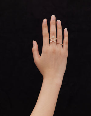 A star shaped ring set with diamonds shown on a hand