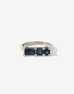 Meadowlark Jewellery’s architecture inspired 1.1ct Hilma Engagement Ring in 9ct White Gold, claw set with a round brilliant cut, princess cut and baguette cut blue sapphire. Atop a fine square band. Fully traceable and ethically sourced blue and green sapphires from Queensland, Australia. A bold and alternative Ceremonial design made to order in New Zealand. Pair with our modern Stella Ring.