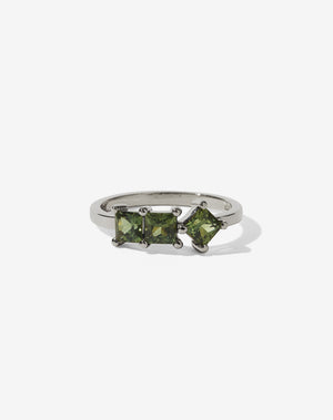 Meadowlark Jewellery’s modern Imogen Engagement Ring in 18ct White Gold claw set with three princess cut green sapphires. Atop a fine square band. Fully traceable and ethically sourced blue and green sapphires from Queensland, Australia. A graphic 3 stone engagement ring, inspired by art and architecture, this Ceremonial design is made to order in New Zealand.