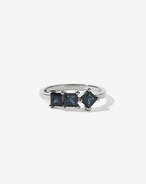 Sapphire: Meadowlark Jewellery’s modern Imogen Engagement Ring in Platinum, claw set with three princess cut blue sapphires. Atop a fine square band. Fully traceable and ethically sourced blue and green sapphires from Queensland, Australia. A graphic 3 stone engagement ring, inspired by art and architecture, this Ceremonial design is made to order in New Zealand.