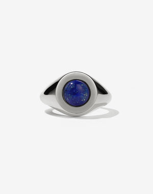A sterling silver ring with a central blue lapis lazuli stone set in a rounded signet style.