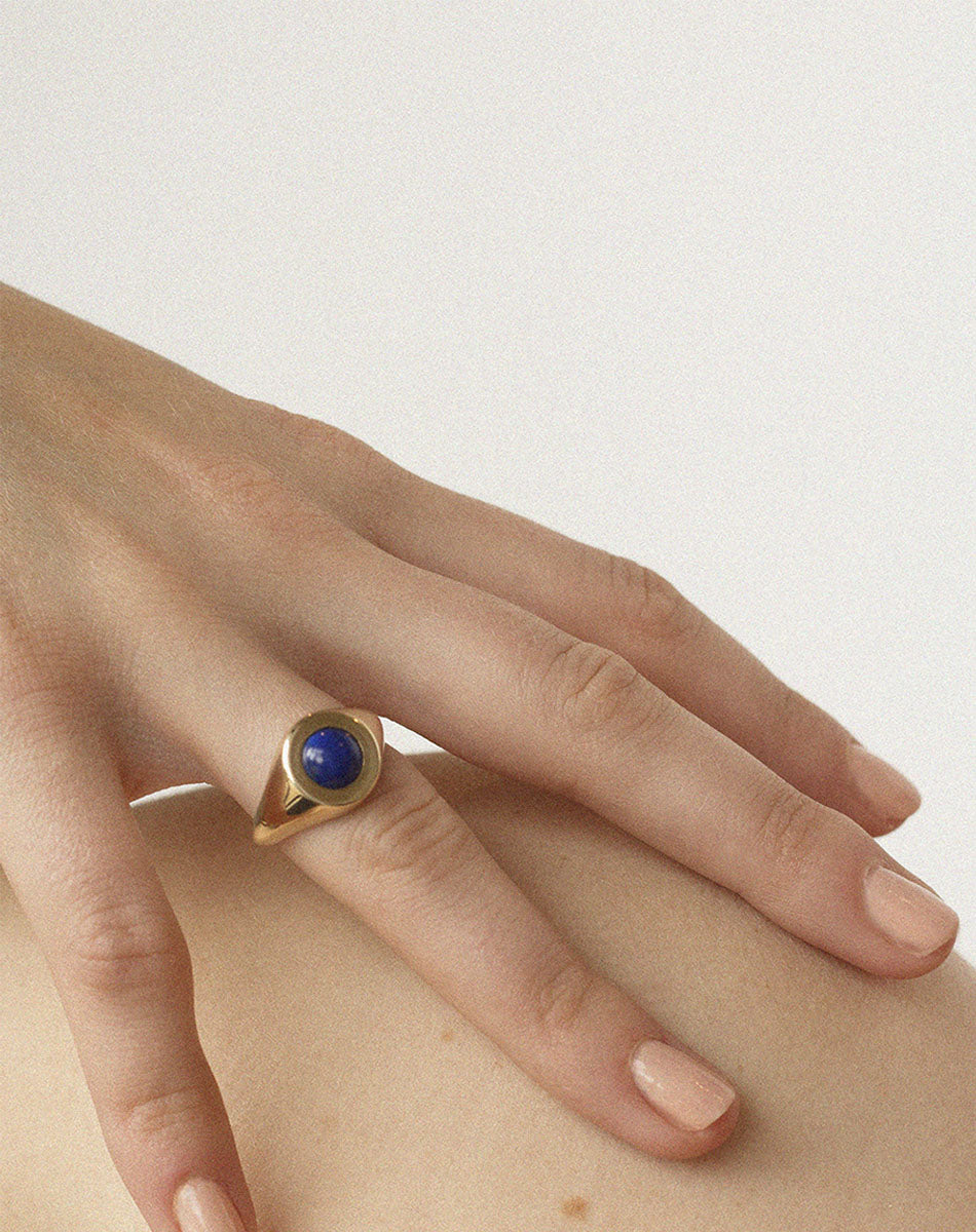 Gold stone set ring with lapis in centre worn by model