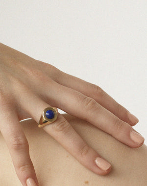 Gold stone set ring with lapis in centre worn by model