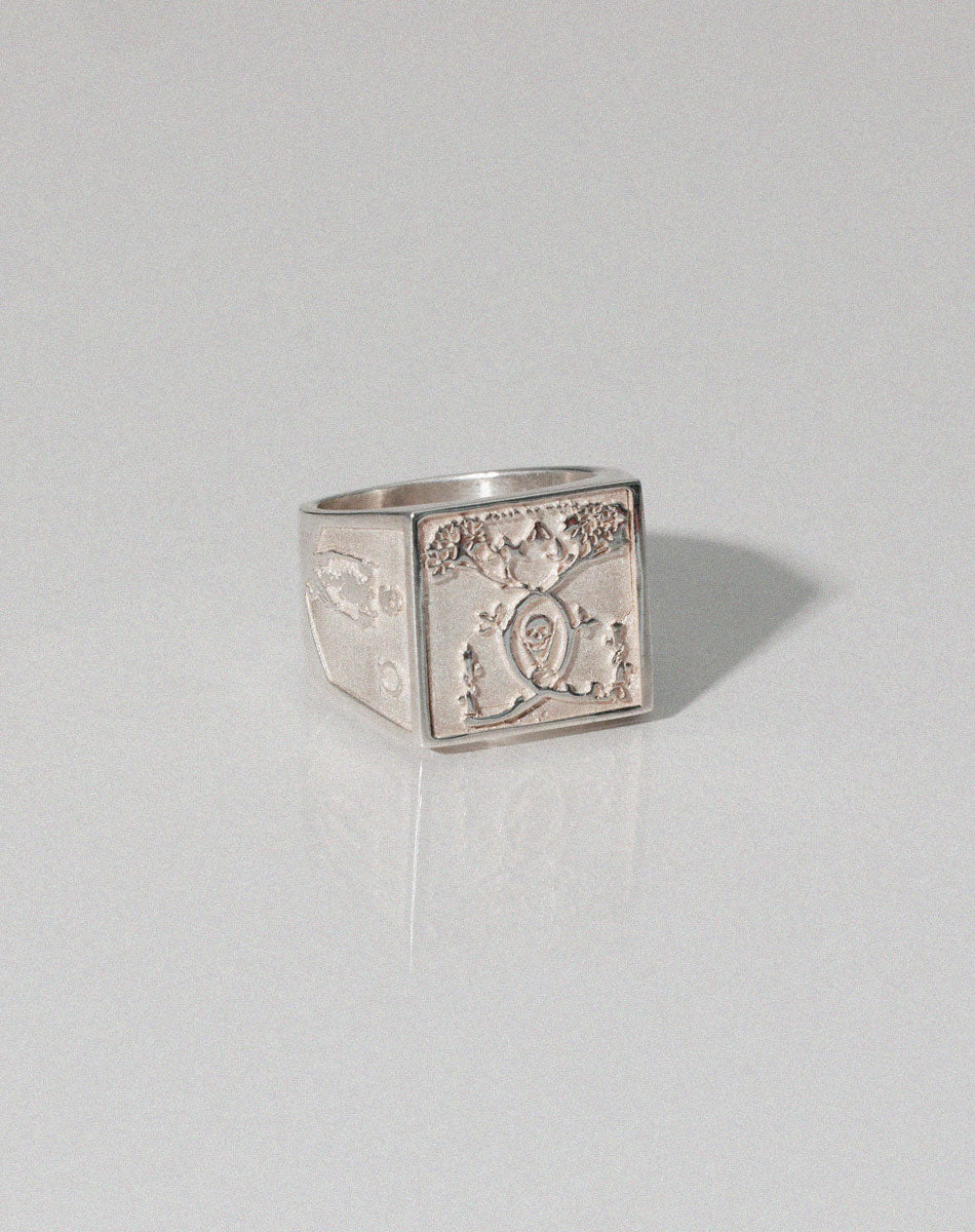 A heavy weighted sterling silver ring with a  collage artwork design.