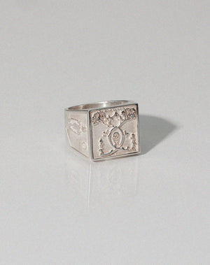 A heavy weighted sterling silver ring with a  collage artwork design.