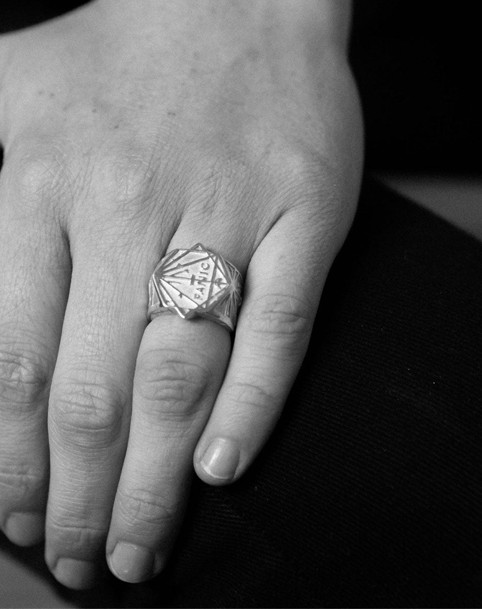 A heavy weighted sterling silver ring with a geometric artwork, designed in collaboration with NZ artist Andrew McLeod. Featuring the word Panic.