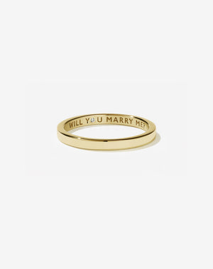 Meadowlark Jewellery’s 0.10ct Stand In Ring in 9ct Yellow Gold, engraved with ‘will you marry me’ and swiss set with a round brilliant cut white diamond. A 2mm wide minimalist placeholder or proposal ring. This Ceremonial design can be worn as a wedding band and is made to order in New Zealand.