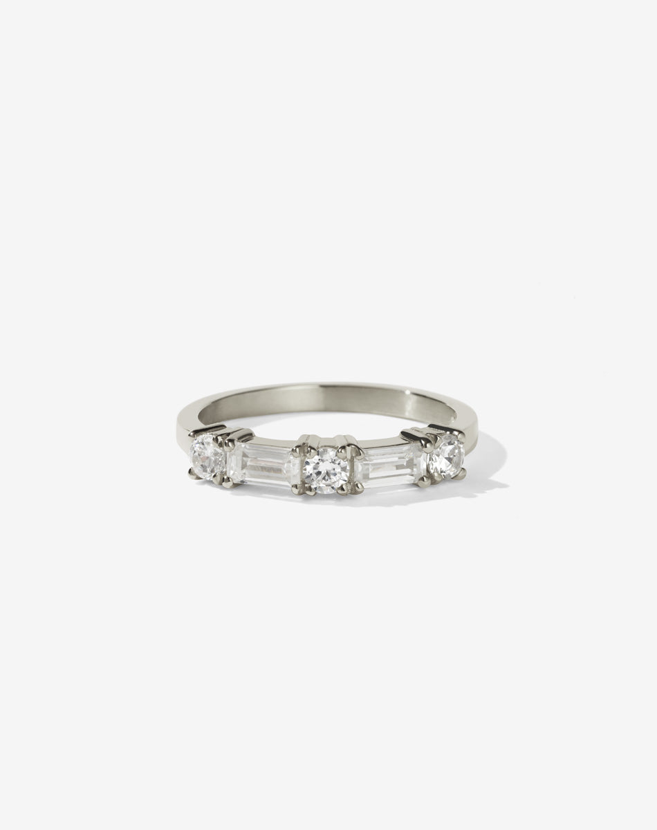 Meadowlark Jewellery’s modern 0.73ct Stella Engagement Ring in 14ct White Gold, claw set with two baguette cut white diamonds and three round brilliant cut white diamonds. Atop a fine square band. A Ceremonial design made to order in New Zealand. Wear as a wedding band with our Hilma Ring or alternative engagement ring.