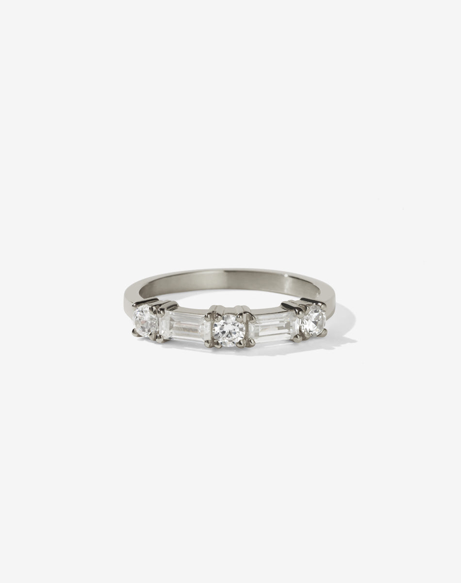 Meadowlark Jewellery’s modern 0.73ct Stella Engagement Ring in 18ct White Gold, claw set with two baguette cut white diamonds and three round brilliant cut white diamonds. Atop a fine square band. A Ceremonial design made to order in New Zealand. Wear as a wedding band with our Hilma Ring or alternative engagement ring.