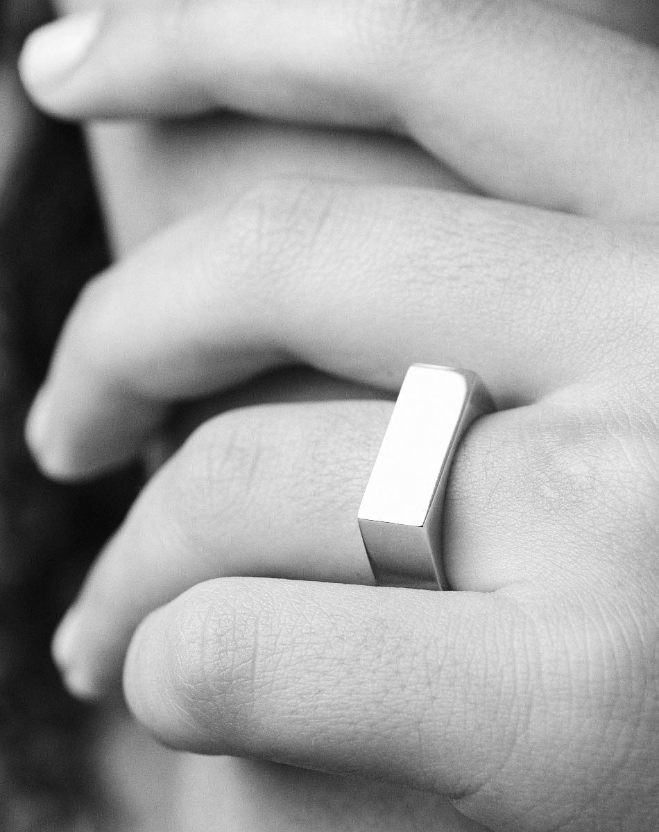 A simple and classic rectangular signet ring shown worn on a hand