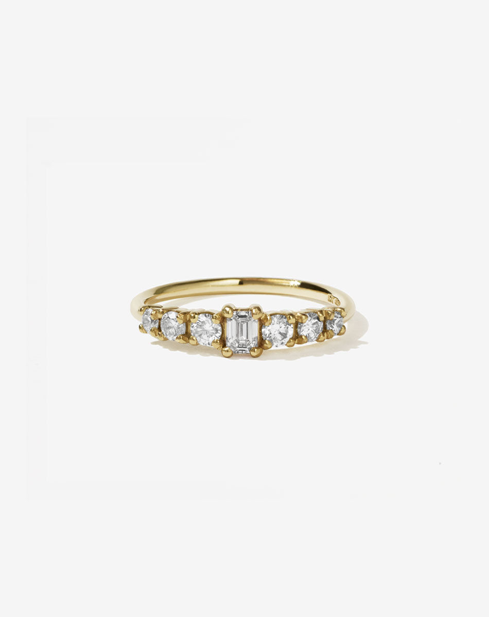 Meadowlark Jewellery’s beautiful Amelie Engagement Ring in 14ct Yellow Gold, claw set with 0.70ct emerald cut and round brilliant cut white diamonds atop a fine round band. A low set, petite seven stone engagement ring this Ceremonial design made to order in New Zealand.