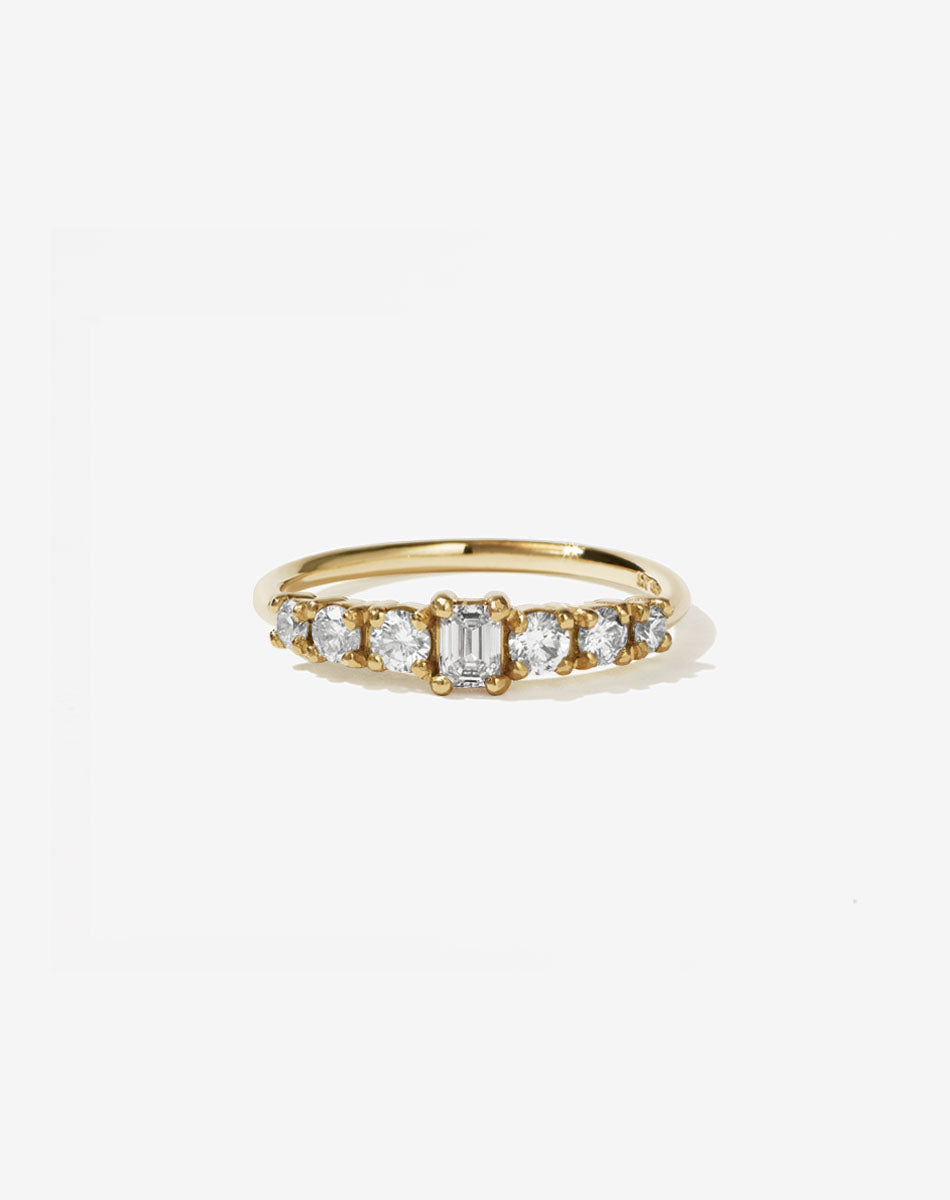 Meadowlark Jewellery’s beautiful Amelie Engagement Ring in 18ct Yellow Gold, claw set with 0.70ct emerald cut and round brilliant cut white diamonds atop a fine round band. A low set, petite seven stone engagement ring this Ceremonial design made to order in New Zealand.