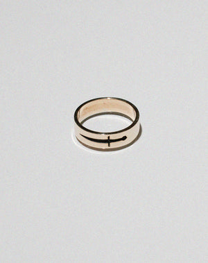 A gold ring featuring an etched and oxidised dagger design on a band.