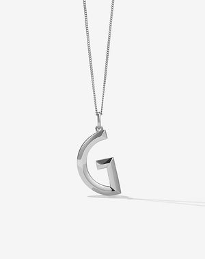 A sterling silver pendant in the shape of a letter, with a faceted design.