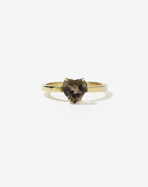 A gold ring with a heart-shaped cut smoky quartz stone set in a simple claw setting on a delicate band.