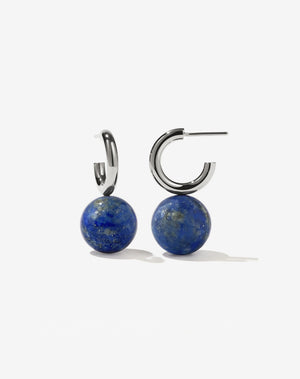 A pair of large hoop earrings with lapis lazuli spheres attached to the hoops.