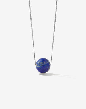 A sterling silver necklace featuring a large lapis lazuli pendant hanging from a fine silver chain.