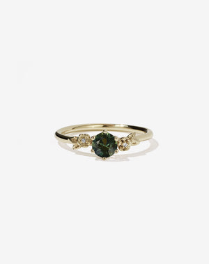 Meadowlark Jewellery’s iconic Alba Engagement Ring in 14ct Yellow Gold, claw set with a round brilliant cut green sapphire. Round band adorned with flowers, set with round brilliant cut white diamonds. Pair with our bestseller, the Alba Band Stone Set or Plain. Made in New Zealand.
