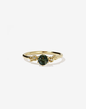 Meadowlark Jewellery’s iconic Alba Engagement Ring in 18ct Yellow Gold, claw set with a round brilliant cut green sapphire. Round band adorned with flowers, set with round brilliant cut white diamonds. Pair with our bestseller, the Alba Band Stone Set or Plain. Made in New Zealand.