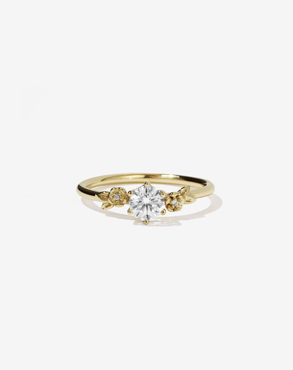 Meadowlark Jewellery’s iconic Alba Engagement Ring in 18ct Yellow Gold, claw set with a 0.50ct round brilliant cut white diamond. Round band adorned with flowers, set with round brilliant cut white diamonds. Pair with our bestseller, the Alba Band Stone Set or Plain. Made in New Zealand.