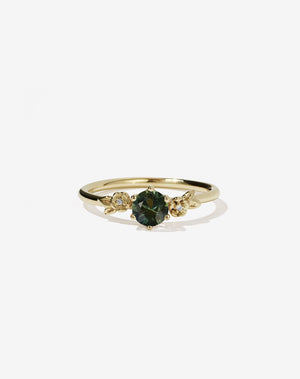 Meadowlark Jewellery’s iconic Alba Engagement Ring in 9ct Yellow Gold, claw set with a round brilliant cut green sapphire. Round band adorned with flowers, set with round brilliant cut white diamonds. Pair with our bestseller, the Alba Band Stone Set or Plain. Made in New Zealand.