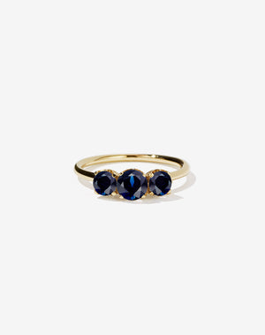 A classic three stone engagement ring in yellow gold with blue sapphires.