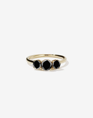 A classic three stone engagement ring in yellow gold with black diamonds.