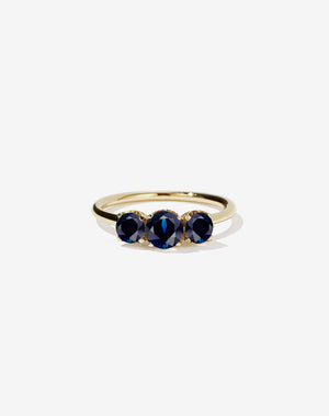 A classic three stone engagement ring in yellow gold with blue sapphires.
