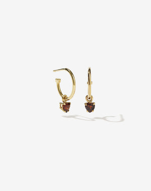 A pair gold plated hoop earrings with heart-shaped garnet stones set in claw settings.