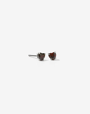 A pair of sterling silver stud earrings with heart-shaped garnet stones.