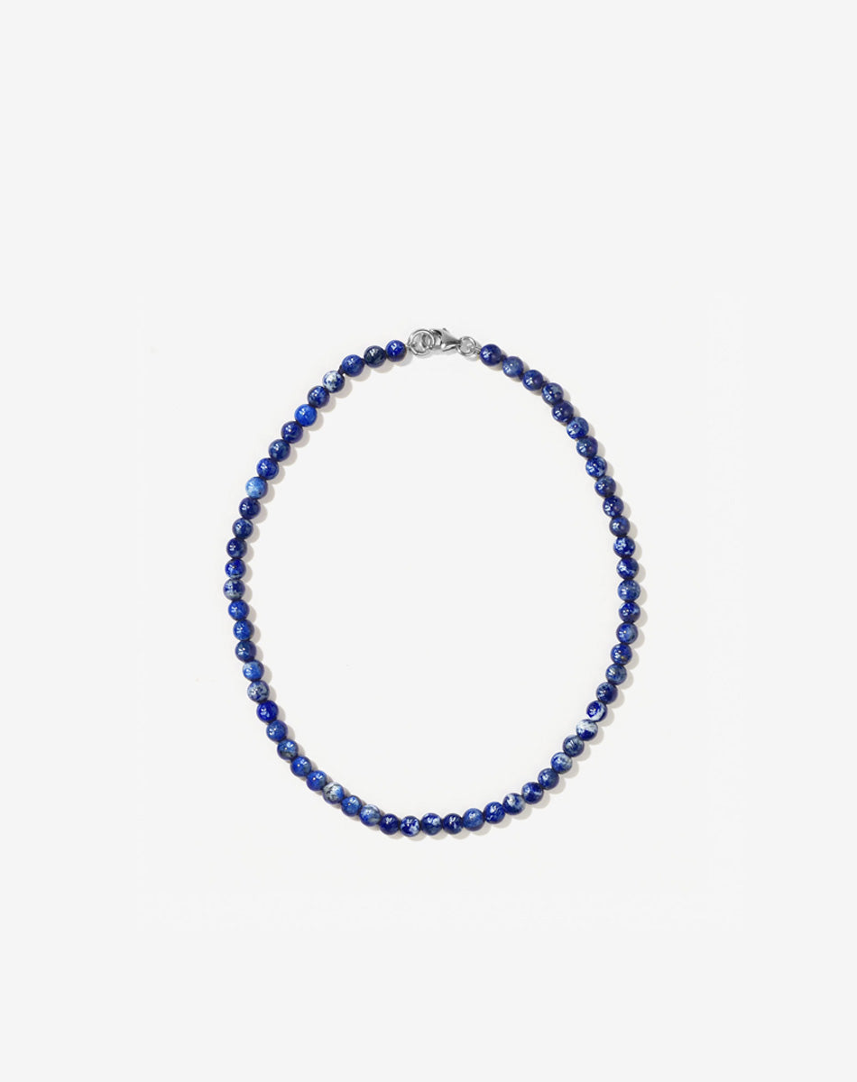 Small spherical lapis lazuli stone beads on silk thread with silver clasp anklet