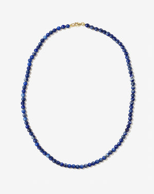 Small spherical lapis lazuli stone beads on silk thread with gold clasp necklace
