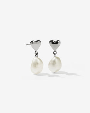 A pair of sterling silver earrings featuring a mini heart stud with freshwater pearl drops.